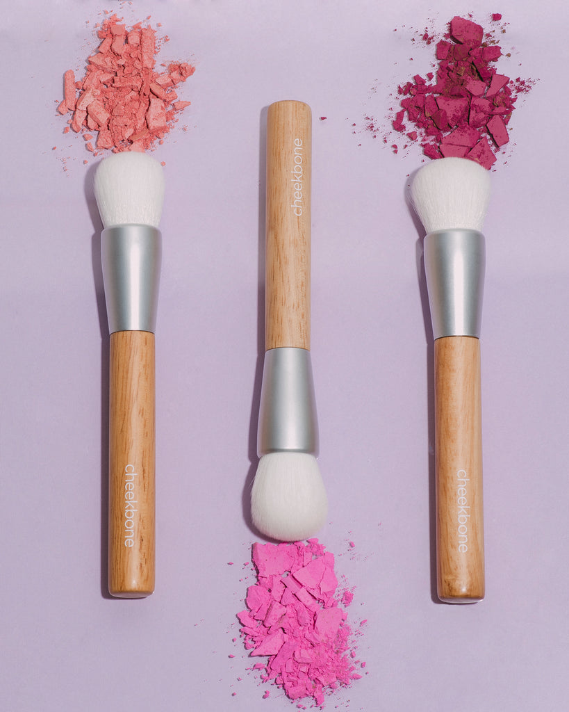 From left to right: Cheekbone Beauty face brush pointing up with peach blush, Cheekbone Beauty face brush pointing down with pink blush, Cheekbone Beauty face brush pointing up with cherry blush